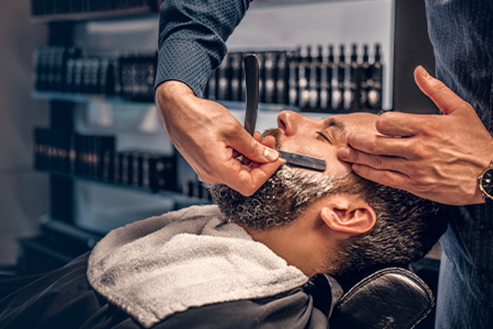 Man getting shaved at the barbers